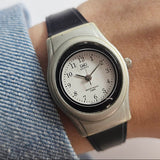 Vintage-style watch on a wrist with a denim shirt