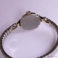 Close-up of a vintage watch with a metal band on a white background