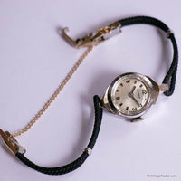 Wristwatch with black strap and gold chain on a white background