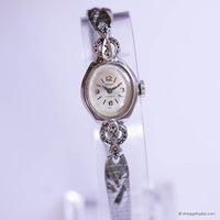 Silver watch with decorative band on a white background