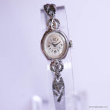 Silver watch with decorative band on a white background