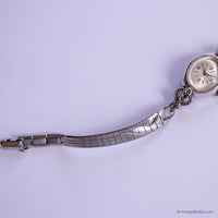 Silver wristwatch with a metal band on a light purple background