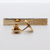 Des boutons de manchette élégants en or vintage, une épingle à cravate ronde et un clip à cravate classique